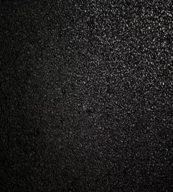 A high-resolution close-up of a black asphalt surface, perfect for backgrounds or graphic design.