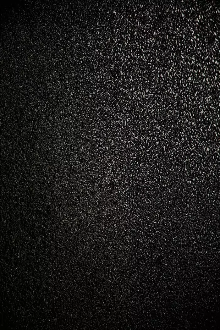 A high-resolution close-up of a black asphalt surface, perfect for backgrounds or graphic design.